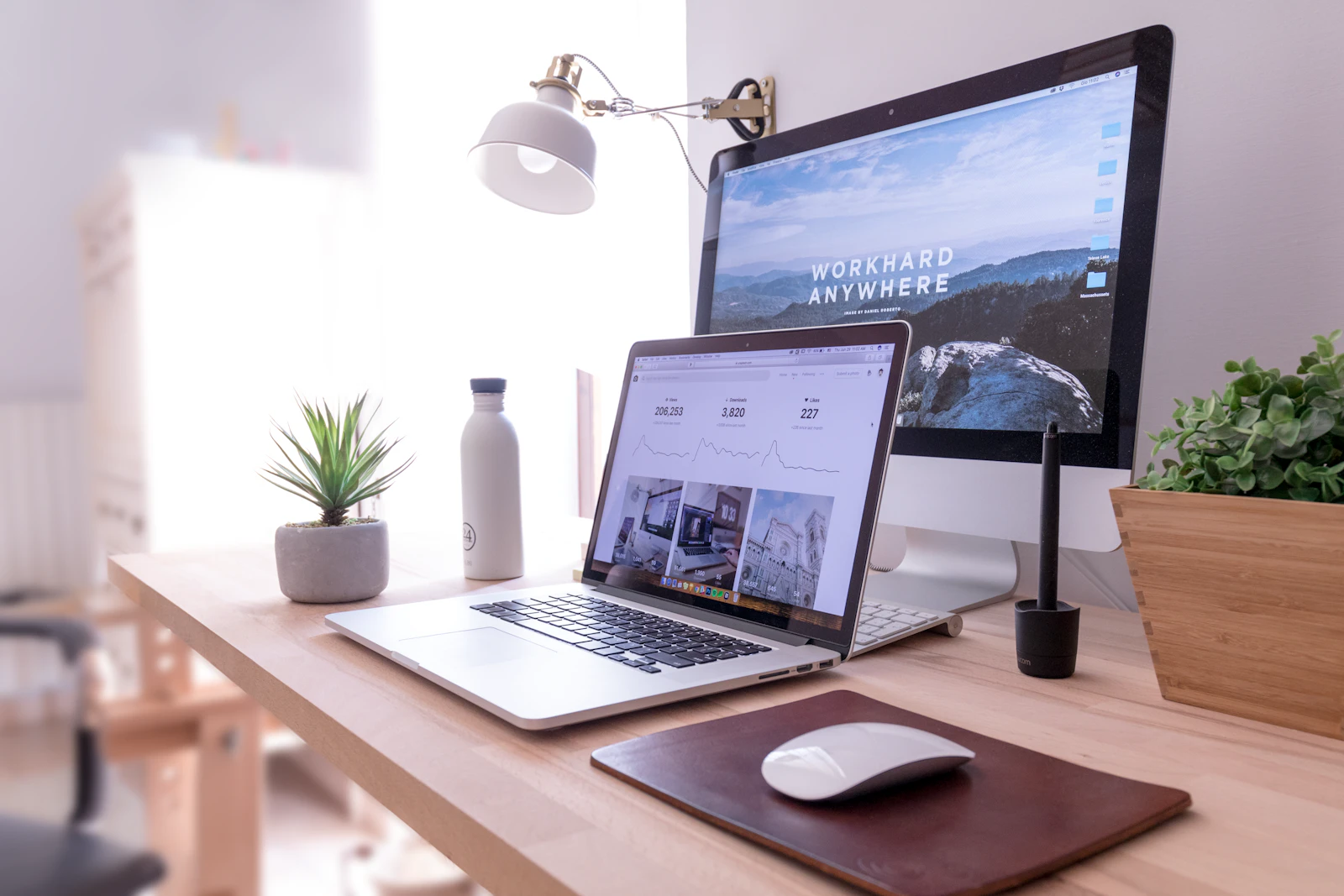 MacBook Pro sur une table à côté d'un iMac blanc et d'une Magic Mouse